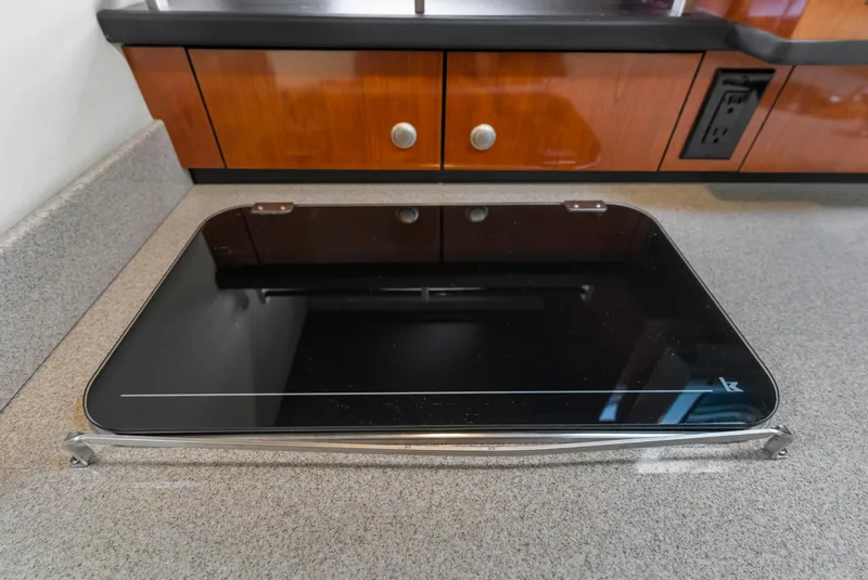 Slide: The Image of Stovetop in 2007 Sea Ray 310 Sundancer yacht kitchen, featuring sleek black glass surface. - 9