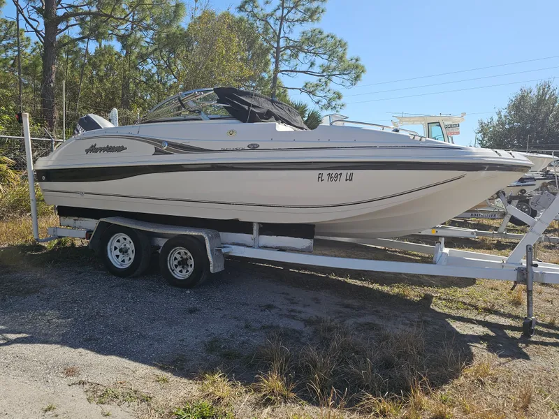 The Image of 2002 Godfrey Hurricane Sundeck 187 boat on trailer outdoors. - 0