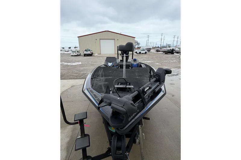 Slide: The Image of 2023 Blazer 650 Pro Tour boat with Garmin equipment, parked outdoors on a cloudy day. - 2