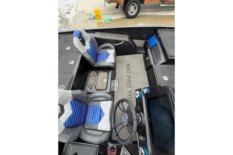 Slide: The Image of 2023 Blazer 650 Pro Tour boat interior with blue and gray seating and steering wheel. - 6
