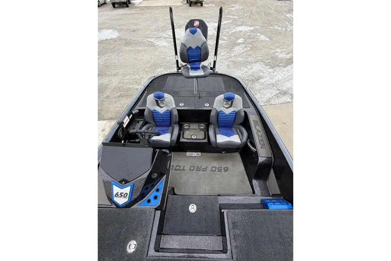 Slide: The Image of 2023 Blazer 650 Pro Tour boat interior with blue and gray seating, steering console, and storage compartments. - 7