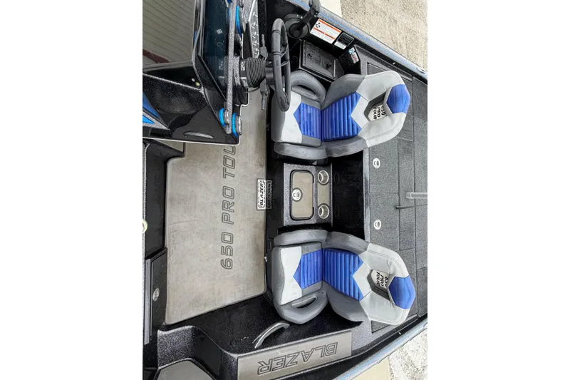 Slide: The Image of 2023 Blazer 650 Pro Tour boat interior with blue and gray seats, steering console. - 8