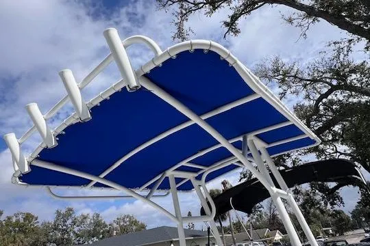 Slide: The Image of Blue canopy on 2008 Angler PANGA 22 boat with rod holders, under a cloudy sky. - 6