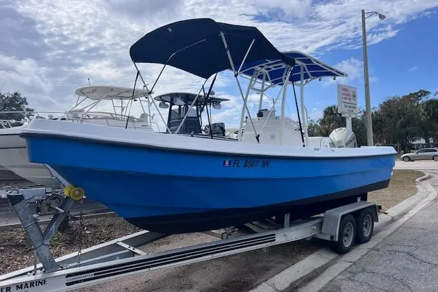 The Image of 2008 Angler PANGA 22 boat on trailer with blue hull and canopy. - 0