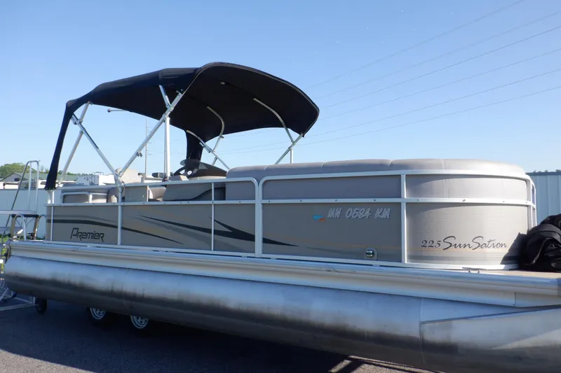 The Image of 2009 Premier 225 Sunsation LTD pontoon boat with canopy, parked on a trailer. - 0