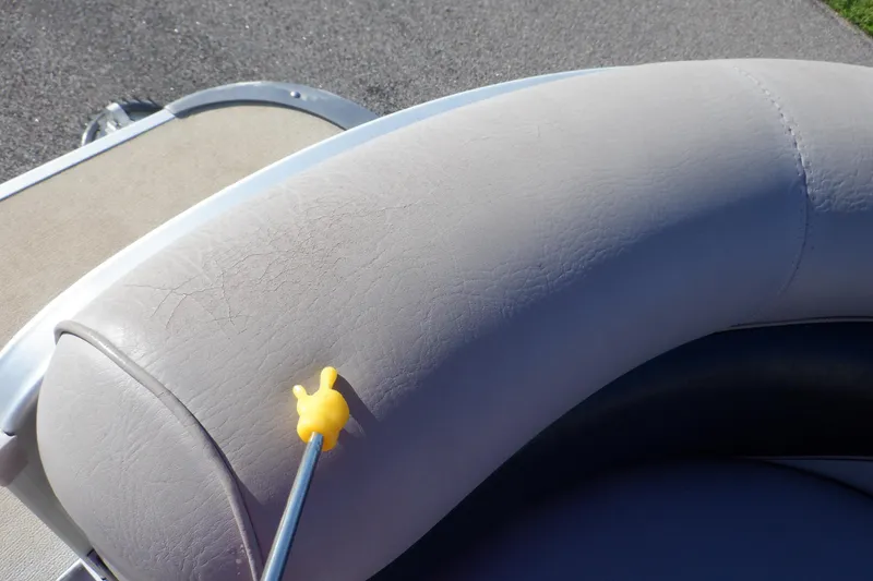 Slide: The Image of Cracked upholstery on 2009 Premier 225 Sunsation LTD boat seat, highlighted with a yellow pointer. - 43