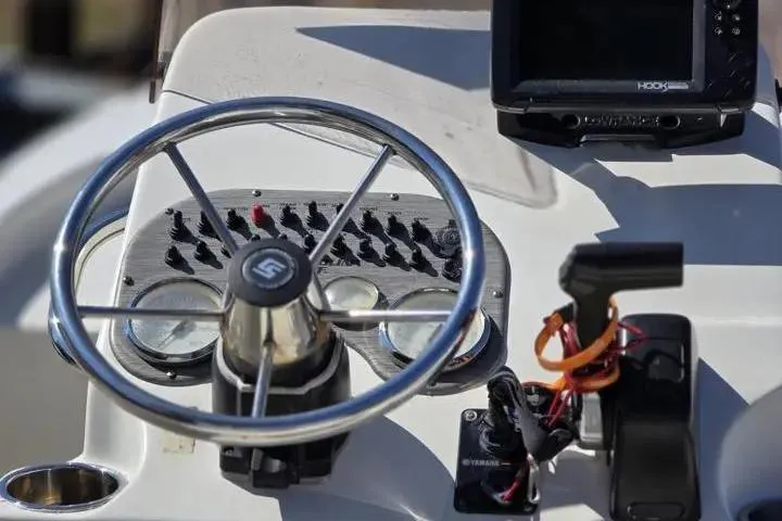 Slide: The Image of 2015 Carolina Skiff JVX Center Console dashboard with steering wheel and controls. - 12