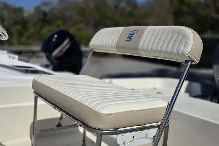 Slide: The Image of 2015 Carolina Skiff JVX Center Console boat seat with white upholstery and chrome frame. - 9