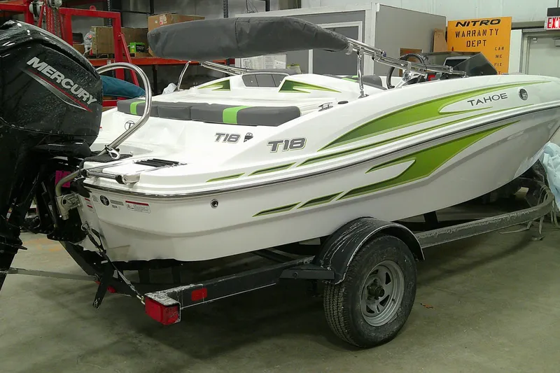 The Image of 2023 Tahoe T18 boat with Mercury engine on trailer in a workshop. - 1