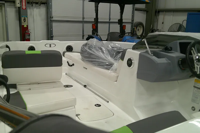 Slide: The Image of 2023 Tahoe T18 boat interior with seating and steering wheel in a garage setting. - 5