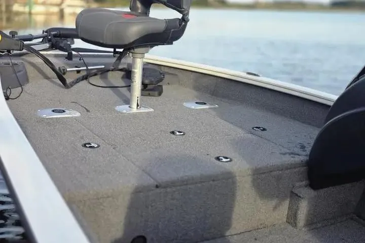 Slide: The Image of 2025 Tracker Pro Team 175 Crappie Edition boat deck with seating, on a calm lake. - 14