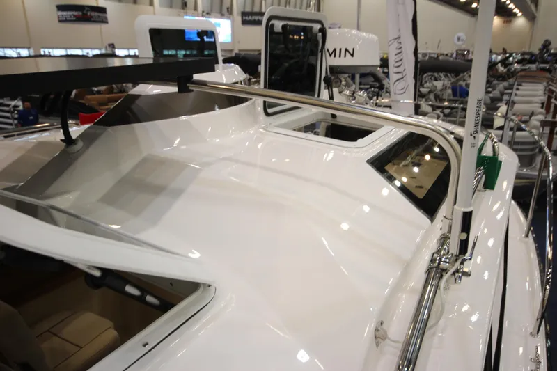 Slide: The Image of 2026 Ranger Tugs R-27 boat showcased indoors, highlighting sleek design and modern features. - 30