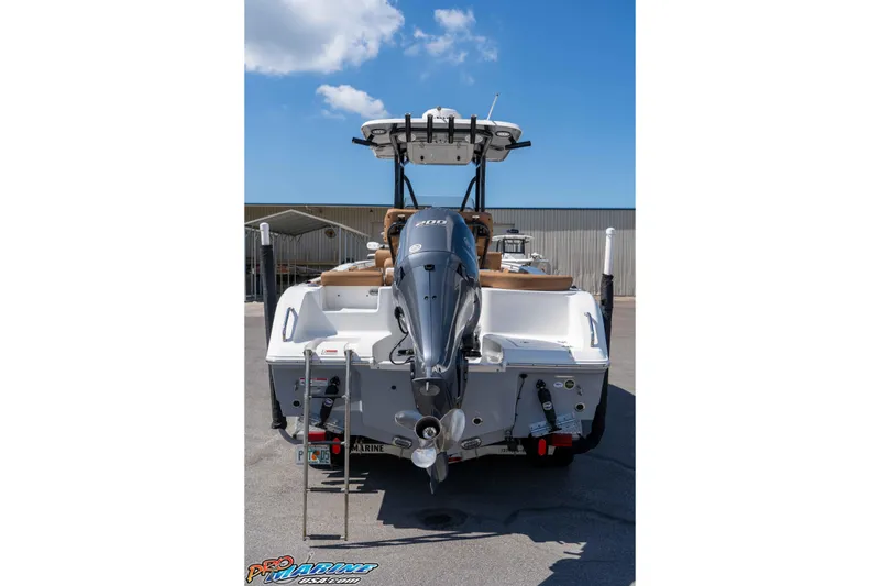 Slide: The Image of 2021 Sea Hunt Ultra 229 boat with outboard motor, docked under clear blue sky. - 13