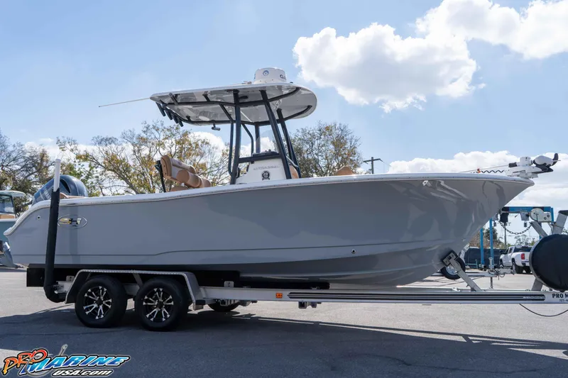 Slide: The Image of 2021 Sea Hunt Ultra 229 boat on trailer, parked outdoors under a clear sky. - 15