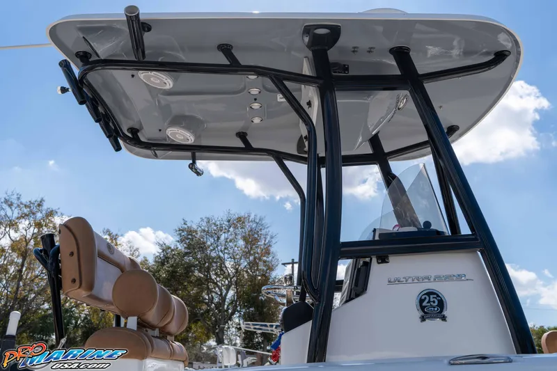 Slide: The Image of 2021 Sea Hunt Ultra 229 boat with T-top and seating, under clear blue sky. - 16