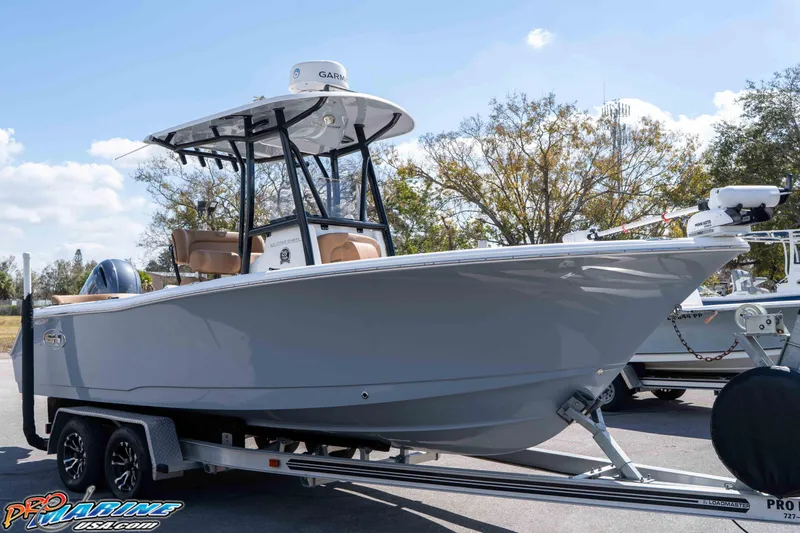 Slide: The Image of 2021 Sea Hunt Ultra 229 boat on trailer, parked outdoors under clear sky. - 2
