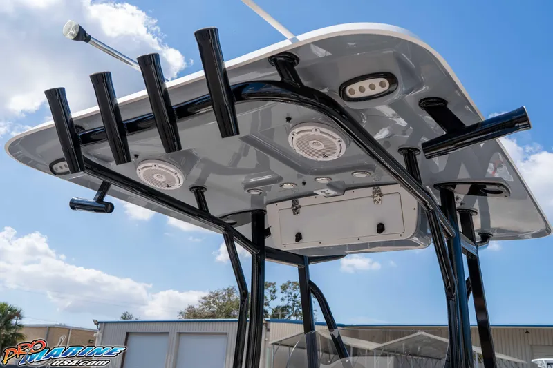 Slide: The Image of 2021 Sea Hunt Ultra 229 boat T-top with rod holders and speakers under a clear blue sky. - 24