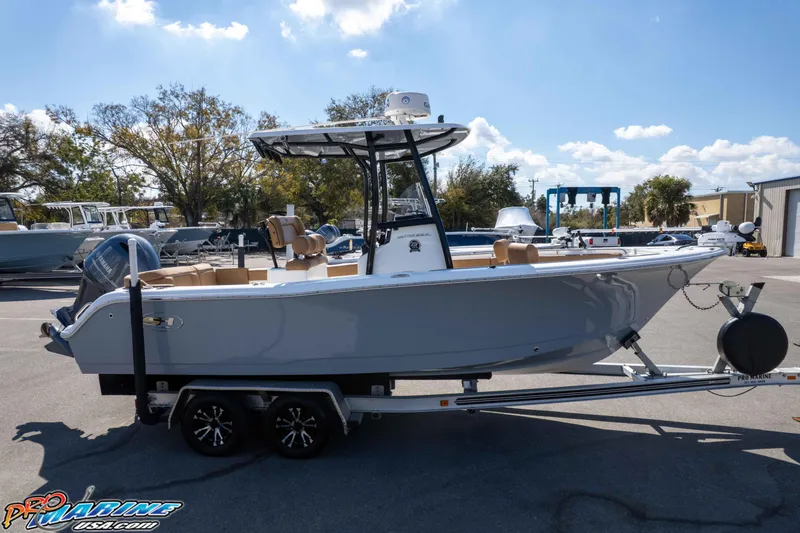 Slide: The Image of 2021 Sea Hunt Ultra 229 boat on trailer, parked outdoors under a clear sky. - 48