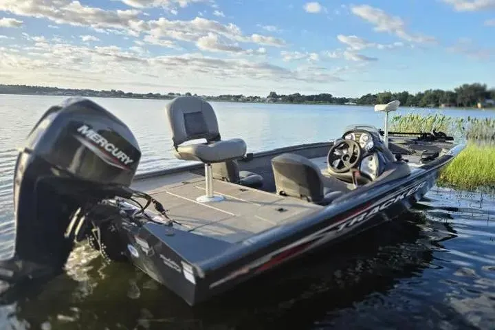 Slide: The Image of 2020 Tracker Pro Team 175 TF boat on a serene lake under a blue sky. - 10