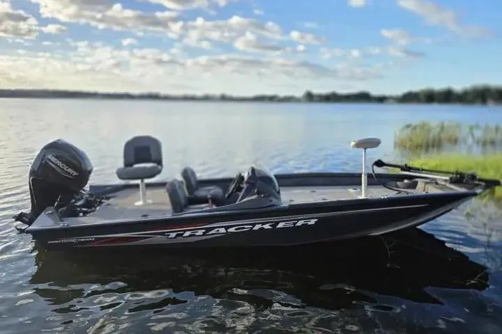 Slide: The Image of 2020 Tracker Pro Team 175 TF boat on a serene lake under a blue sky. - 12
