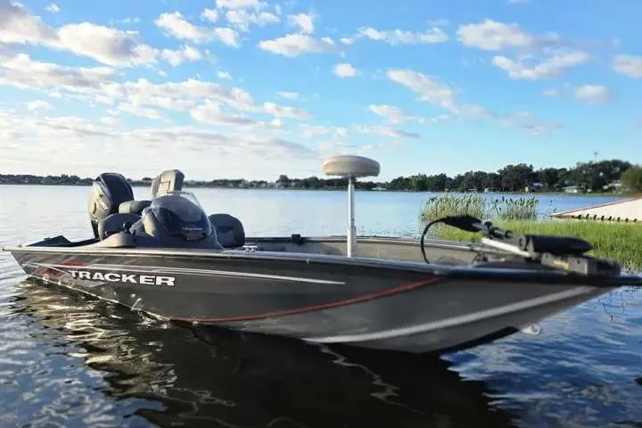 Slide: The Image of 2020 Tracker Pro Team 175 TF boat on a serene lake under a blue sky. - 13