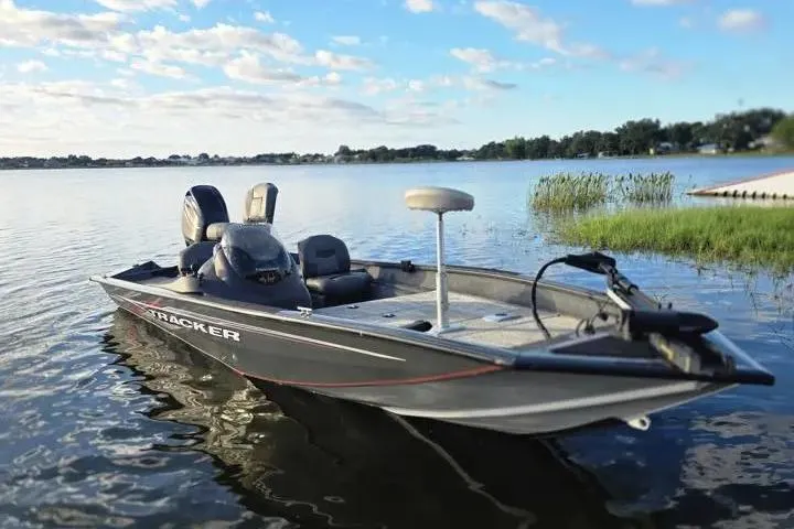 Slide: The Image of 2020 Tracker Pro Team 175 TF boat on a serene lake under a blue sky. - 15