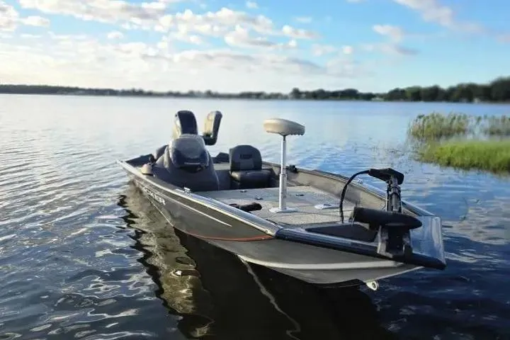 Slide: The Image of 2020 Tracker Pro Team 175 TF boat on a calm lake under a blue sky. - 17