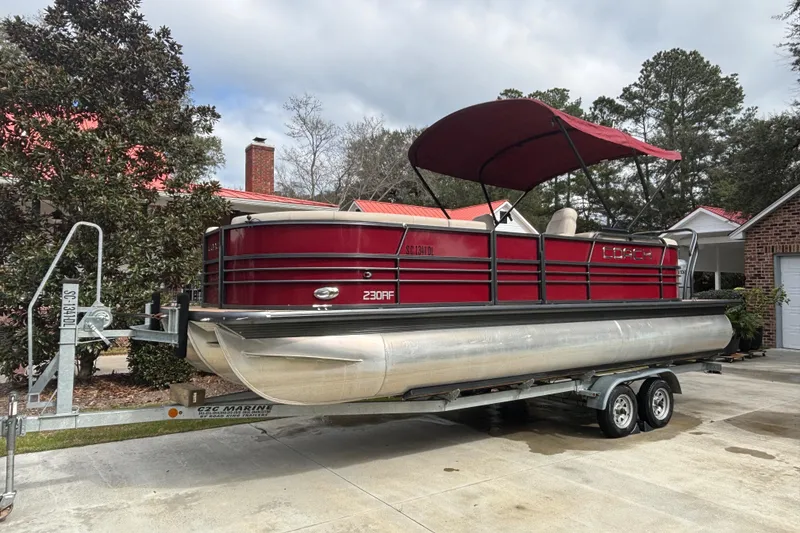 The Image of 2018 Coach Pontoons 230 RF on trailer, red canopy, parked in driveway. - 0