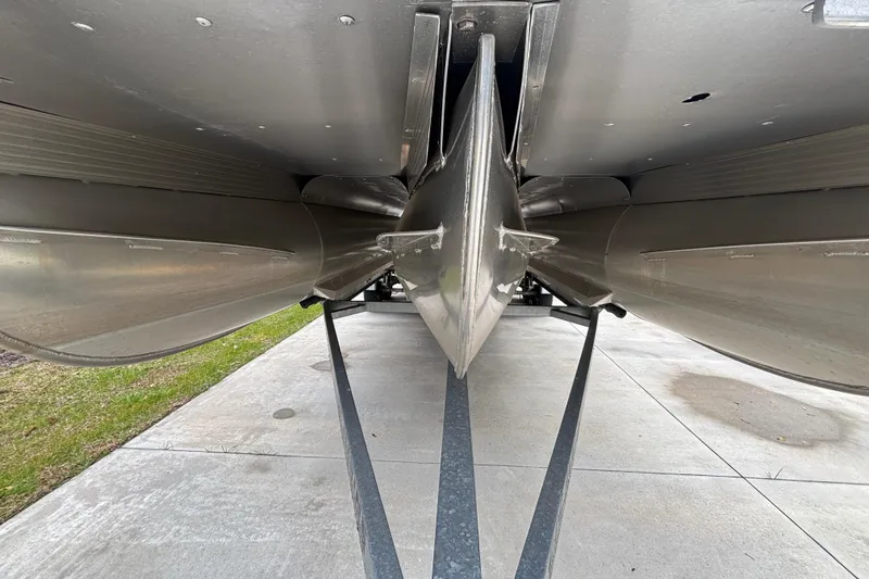 Slide: The Image of Underneath view of 2018 Coach Pontoons 230 RF, showcasing pontoons with Lifting strakes and the Galvanized Road King trailer. - 16
