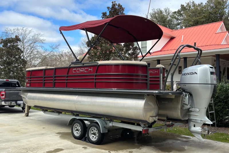 Slide: The Image of 2018 Coach Pontoons 230 RF with Honda engine on trailer, parked in driveway. - 2