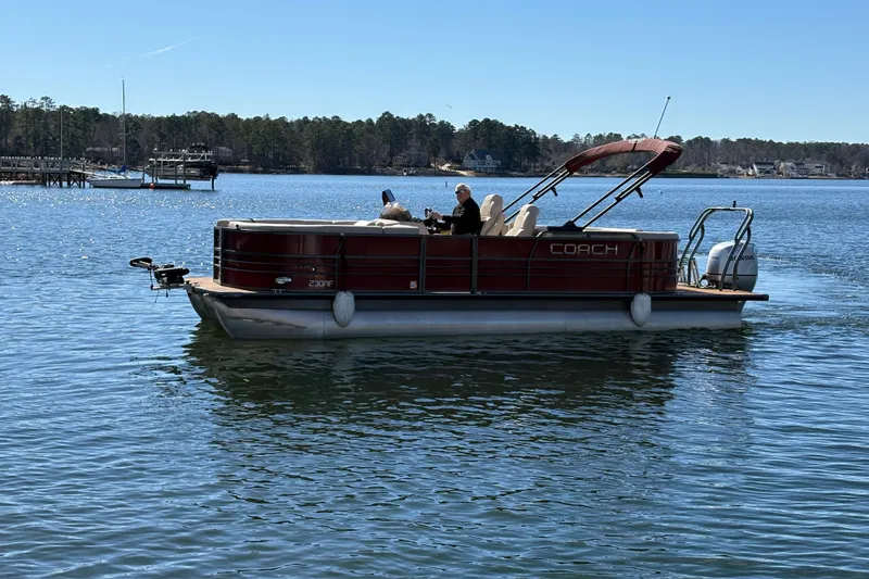 Slide: The Image of 2018 Coach Pontoons 230 RF on a serene lake with passengers enjoying the view. - 4