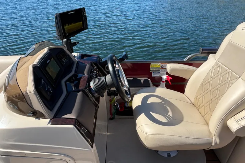 Slide: The Image of 2018 Coach Pontoons 230 RF helm with beige captain's chair and navigation equipment. - 7