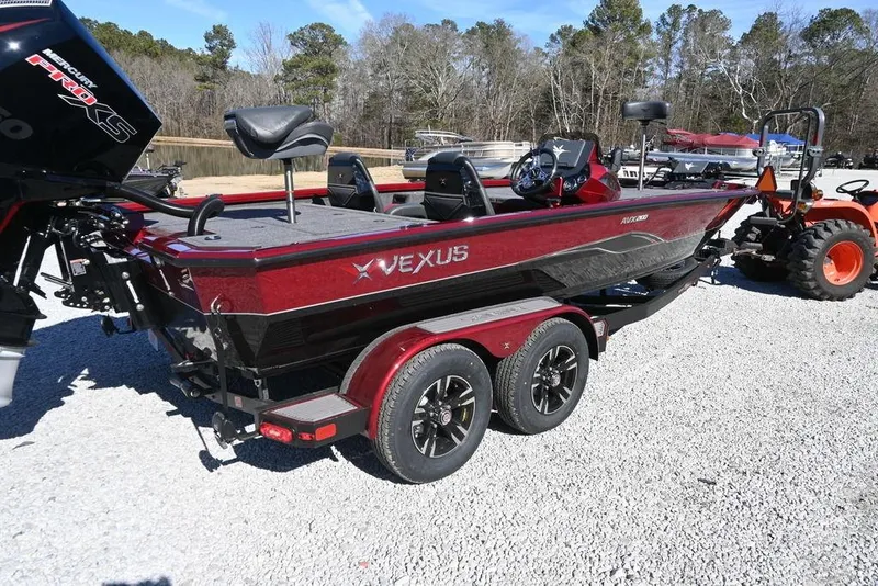 Slide: The Image of 2026 Vexus AVX 2100 boat on trailer, red and black design, parked outdoors. - 2