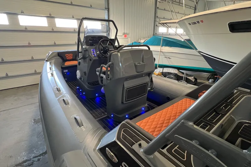 Slide: The Image of 2024 Highfield Sport 560 boat interior with modern design and illuminated controls in a garage. - 10