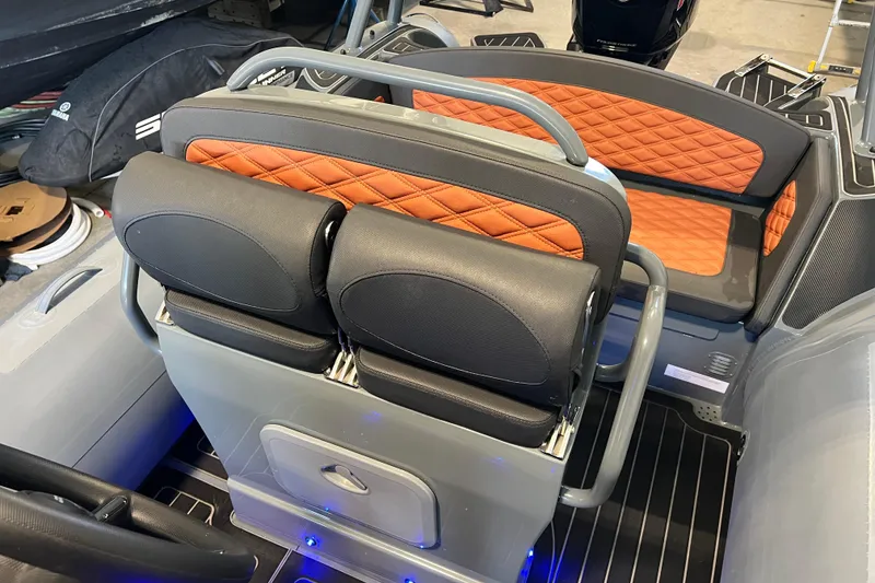 Slide: The Image of 2024 Highfield Sport 560 boat interior with orange and black seating, showcasing modern design. - 11