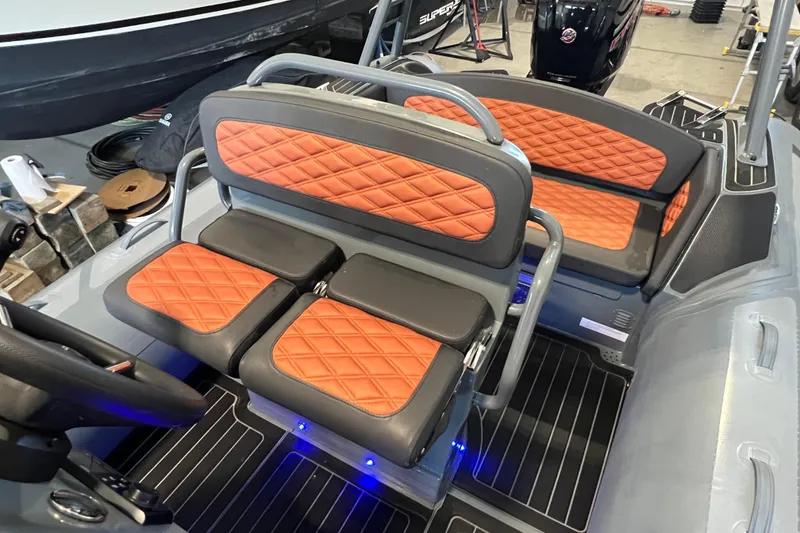 Slide: The Image of 2024 Highfield Sport 560 boat interior with orange diamond-stitched seating and modern design. - 12
