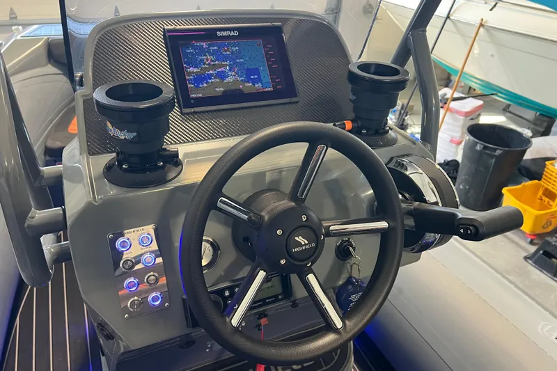 Slide: The Image of 2024 Highfield Sport 560 boat dashboard with steering wheel and navigation display. - 14