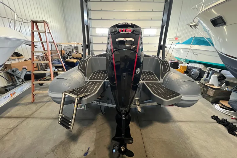 Slide: The Image of 2024 Highfield Sport 560 boat with Mercury 115 engine in a storage facility. - 2