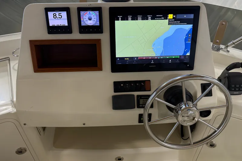 Slide: The Image of 2021 Sabre 42 Fly Bridge helm with navigation screens and steering wheel. - 17
