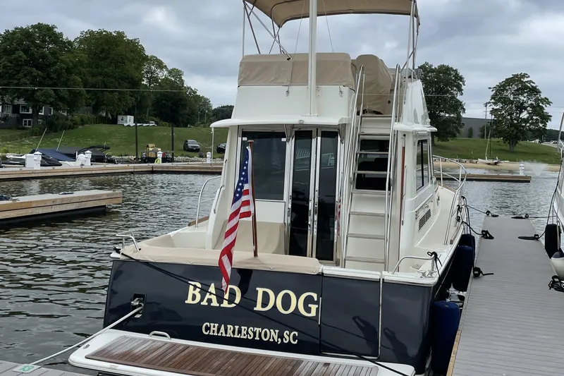 Slide: The Image of 2021 Sabre 42 Fly Bridge yacht docked, featuring "Bad Dog" name and American flag. - 3