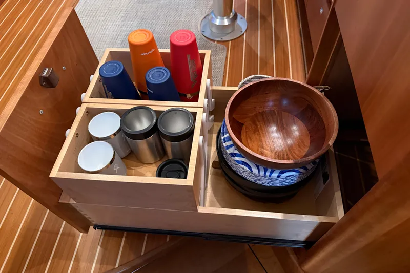 Slide: The Image of Storage drawer in 2021 Sabre 42 Fly Bridge with cups and wooden bowls. - 34
