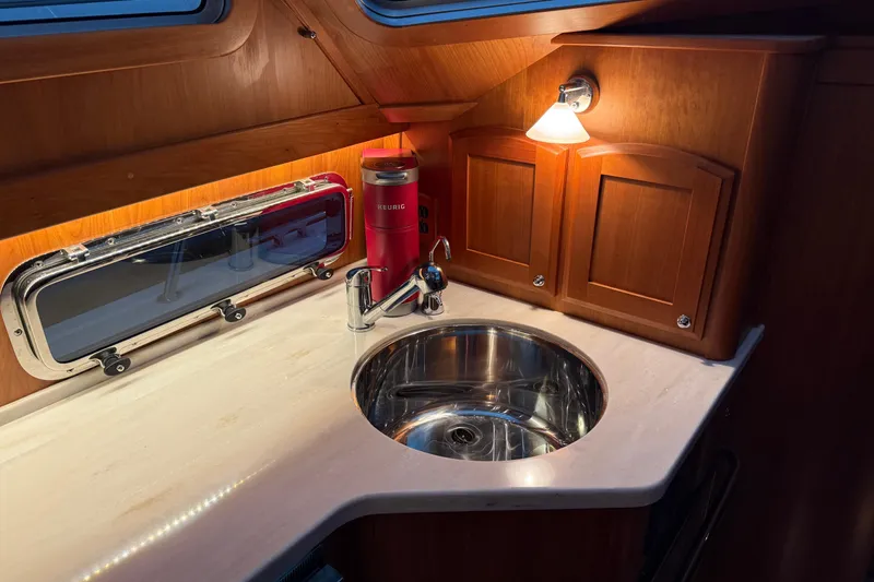 Slide: The Image of Luxurious Sabre 42 Fly Bridge 2021 yacht kitchen with sink, wooden cabinets, and Keurig coffee maker. - 38