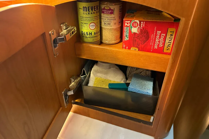 Slide: The Image of Cabinet interior on 2021 Sabre 42 Fly Bridge with cleaning supplies and tea. - 39