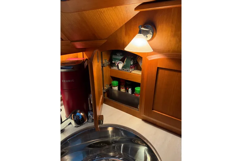Slide: The Image of Interior of 2021 Sabre 42 Fly Bridge yacht kitchen with wooden cabinets and lighting. - 40