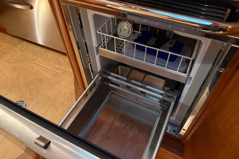 Slide: The Image of Open refrigerator drawer on 2021 Sabre 42 Fly Bridge yacht, showing interior storage. - 42