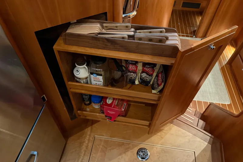 Slide: The Image of Cabinet with spices and cutting boards in 2021 Sabre 42 Fly Bridge yacht kitchen. - 44
