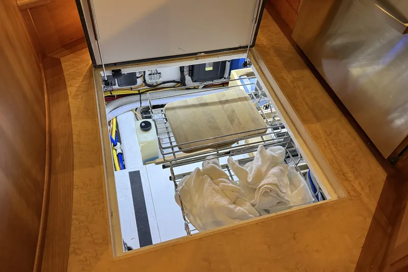 Slide: The Image of Hidden storage compartment in 2021 Sabre 42 Fly Bridge yacht, featuring organized utilities and towels. - 46