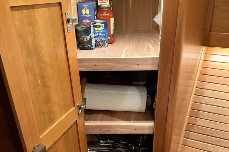 Slide: The Image of Open wooden cabinet with pantry items in Sabre 42 Fly Bridge, 2021 model. - 49