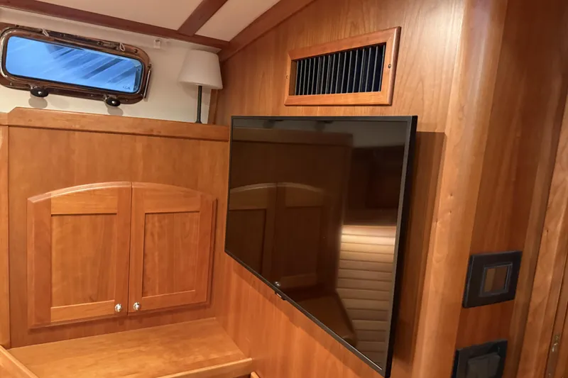 Slide: The Image of Interior of 2021 Sabre 42 Fly Bridge with wood paneling and mounted TV. - 53