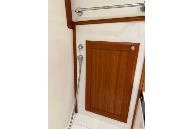 Slide: The Image of 2021 Sabre 42 Fly Bridge shower area with wooden panel and handheld showerhead. - 58